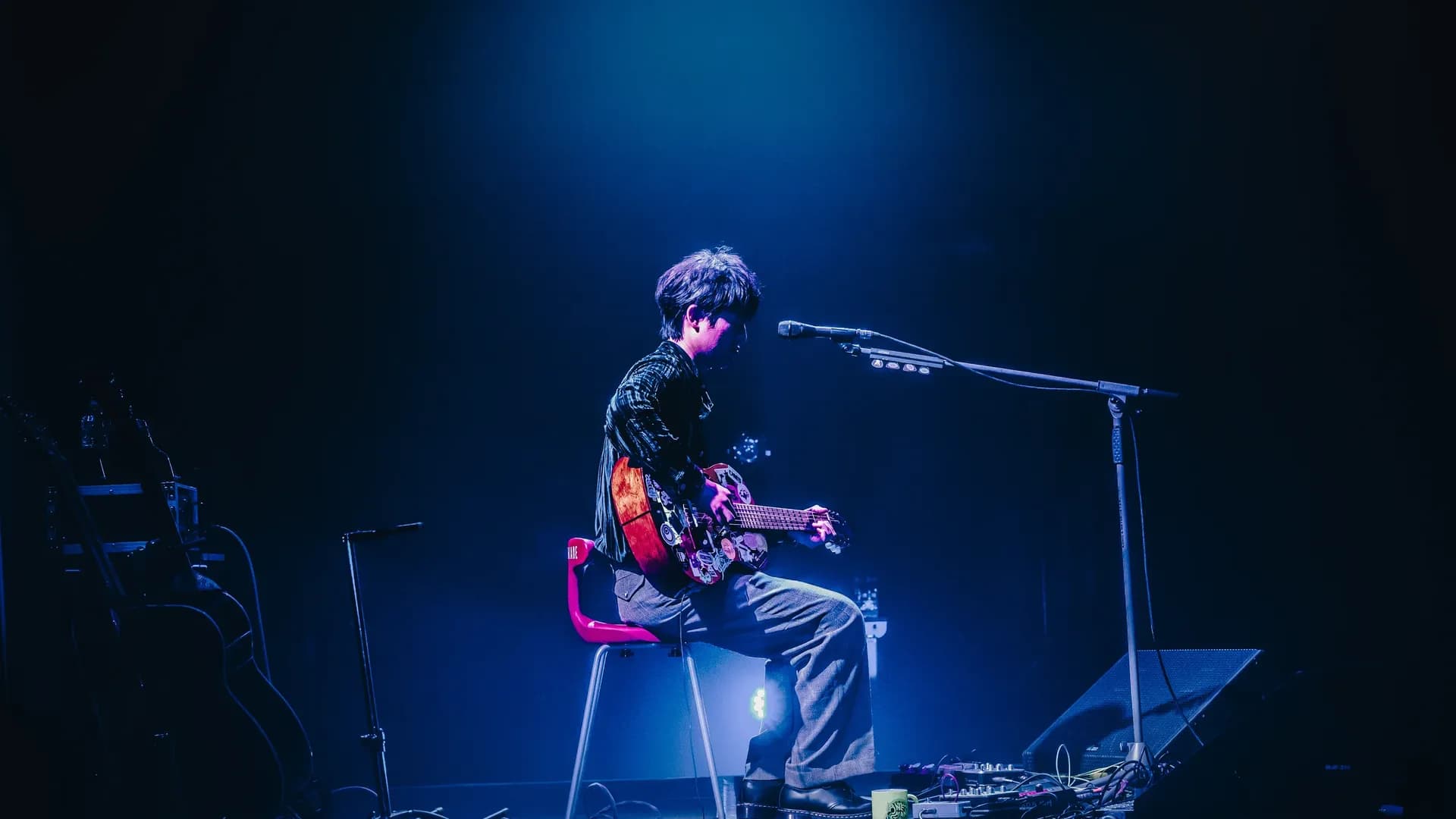 青い照明のステージでギターを弾く尾崎裕哉（2026年ライブ写真）